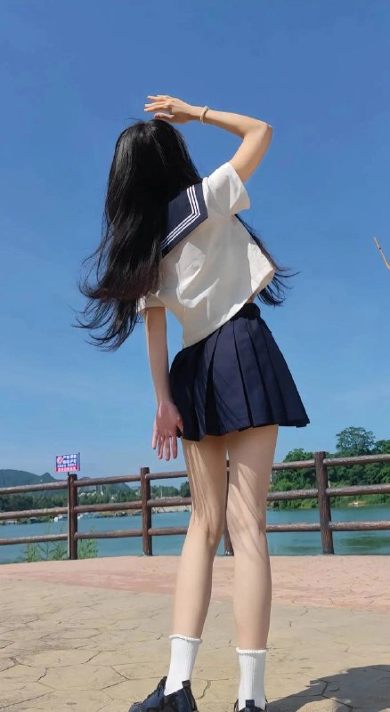 长头发和蓝色和白色衬衫的女人举起她的手臂