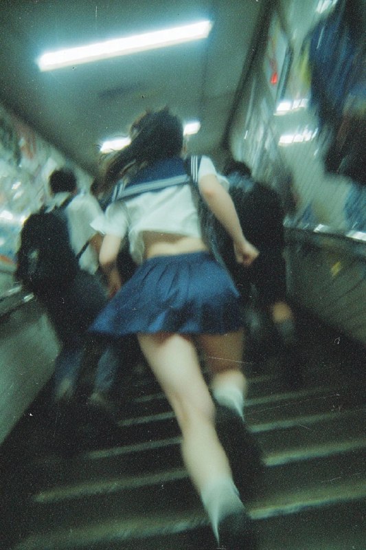 一位穿着蓝色裙子的女人正在爬楼梯