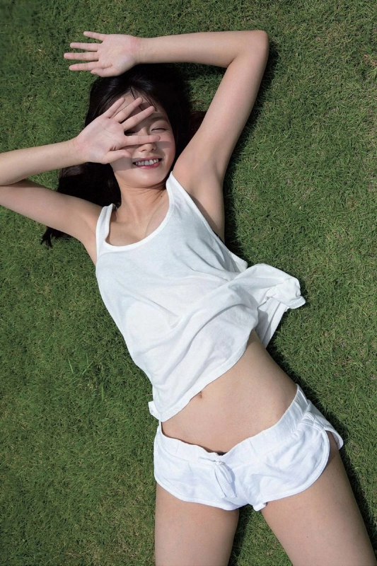 穿着白色衬衫和白色短裤的女人躺在草地上