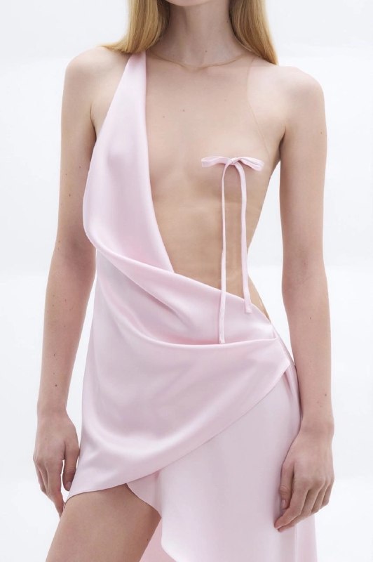 女人穿着一个粉红色的裙子与一个弓