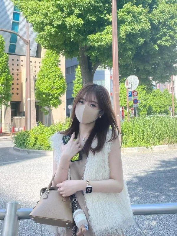 女人戴着面具和一件白色的外套