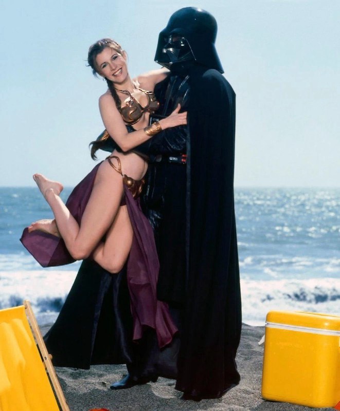 穿着星球大战服装的女人拥抱一个穿着达斯·瓦德服装的男人