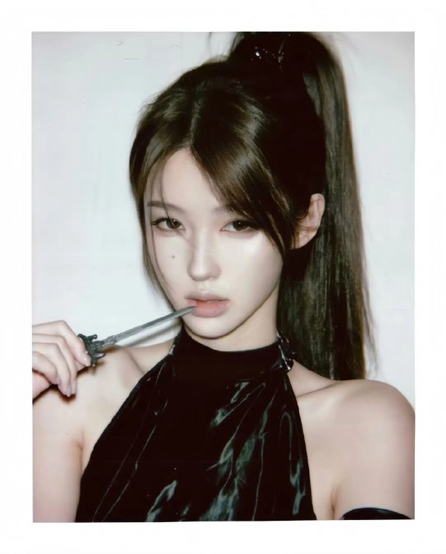 女人戴着一只马尾巴和一件黑色的裙子,拿着一根牙刷