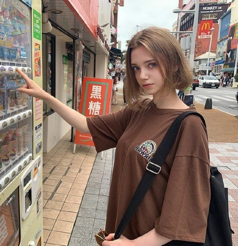 穿着棕色衬衫的女人拿着一台售货机