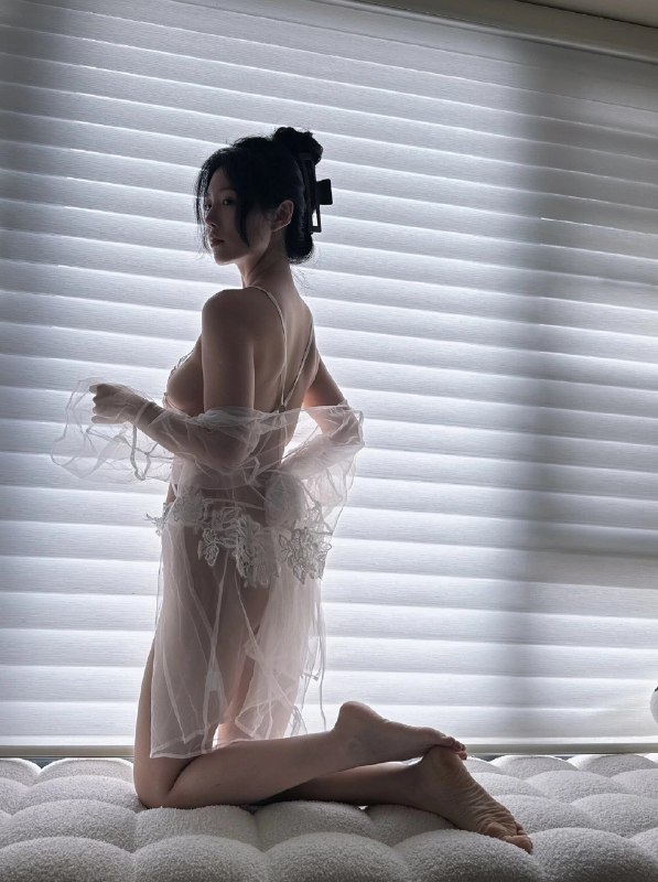 穿着白色衣服的女人站在窗前