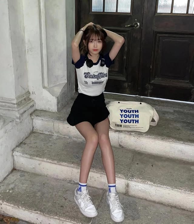 女人坐在楼梯上带着一个袋子