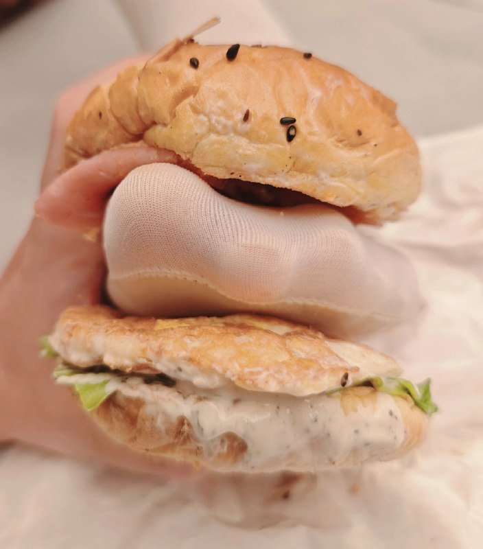 人拿着一顿两半的三明治