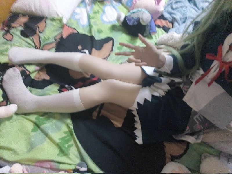 穿着绿色衣服的女孩坐在床上