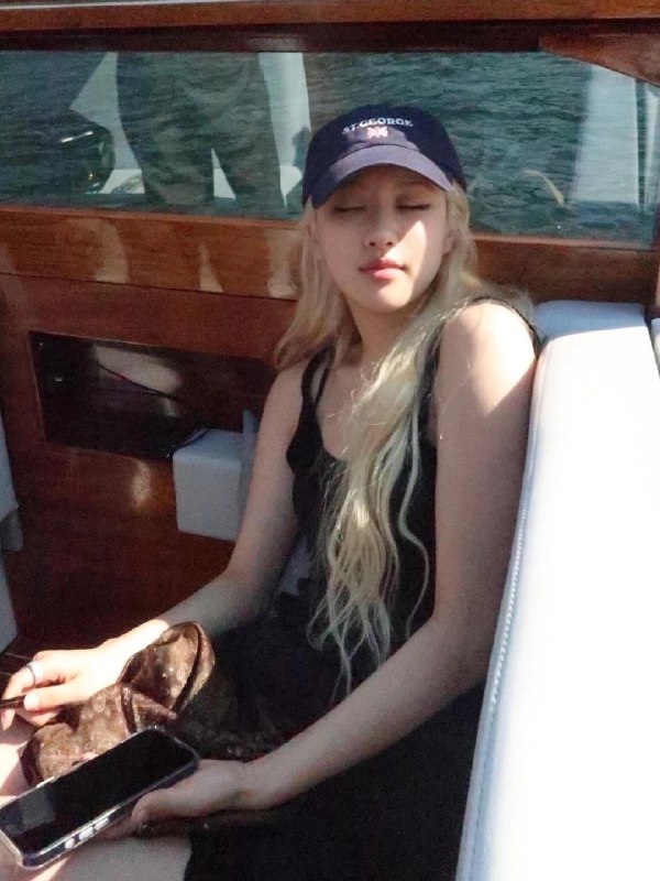 一位穿着一顶帽子和一件黑色衬衫的女人坐在船上