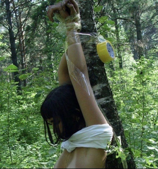 女人在森林里被绑在一棵树上