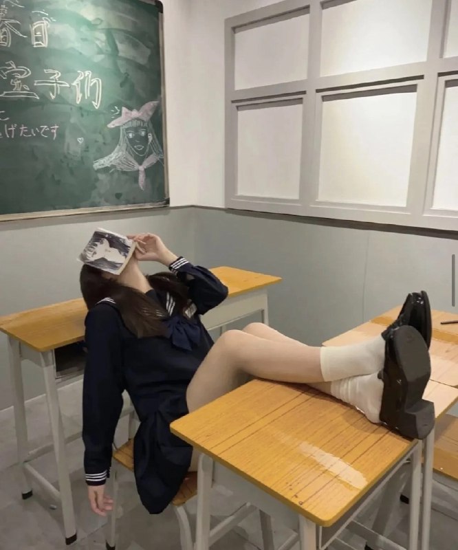 女孩在坐在桌子上读一本书