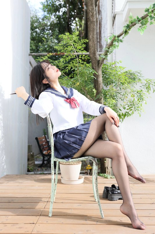 穿着水手服的女人坐在椅子上