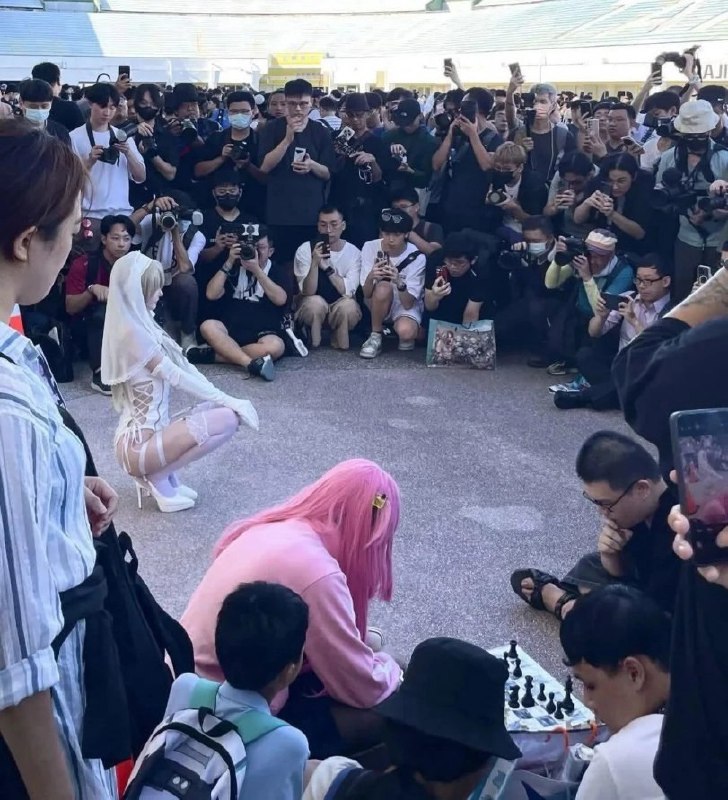 穿着白色衣服的女人跪在地上,站在一个象棋板前