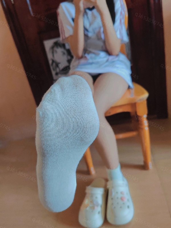 穿着白色衬衫和白色鞋子的女人坐在椅子上