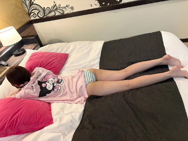 穿着粉红色衬衫的女孩躺在床上