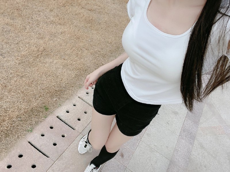 穿黑色短裤和白色衬衫的女人为一张照片