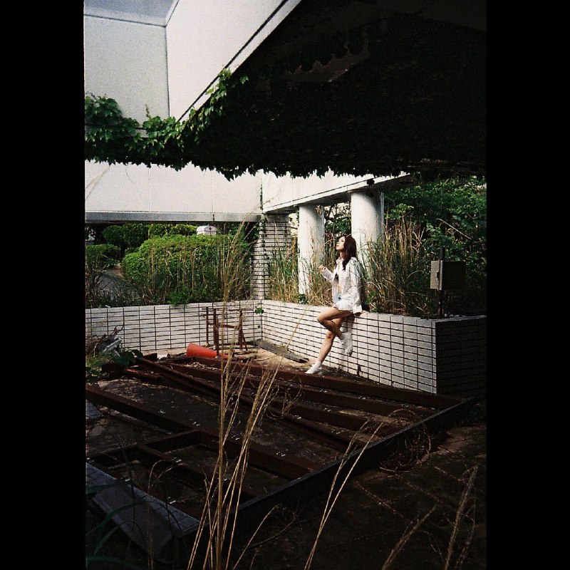 女人坐在墙上,俯瞰建筑物