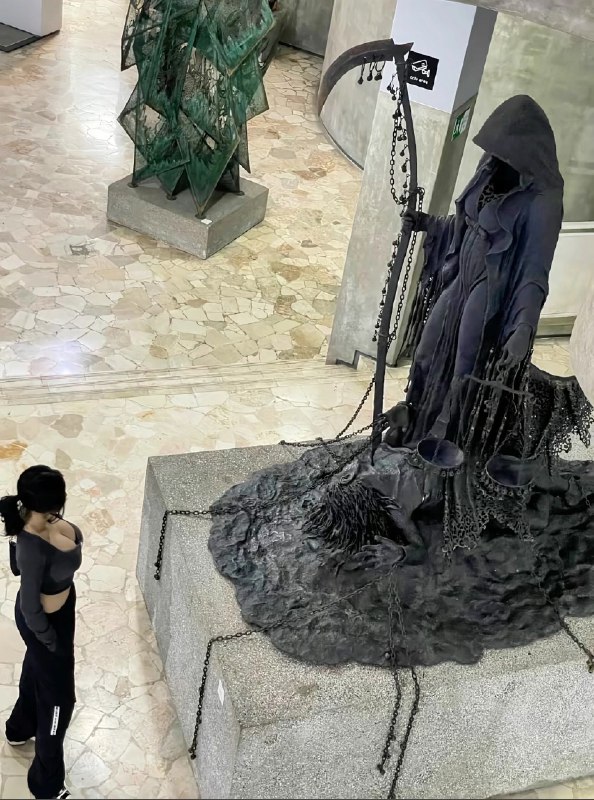 女人站在一个雕像的骨骼,持有一个尺度