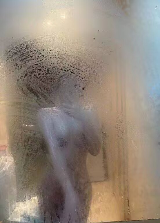 在朦胧的镜面之后，她与自己的倒影低语，水汽缭绕间，每一颗水滴都承载着一段未诉的故事